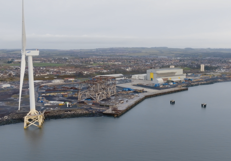 Coast with industrial building and a wind turbine